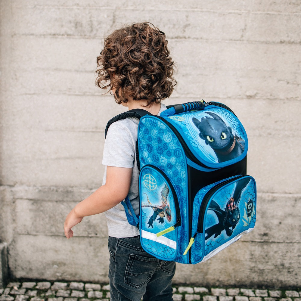 Kleiner Junge mit Locken trägt den Dragons Ranzen zur Schule