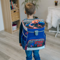 Junge trägt Spiderman Schulranzen auf Rücken im Wohnzimmer