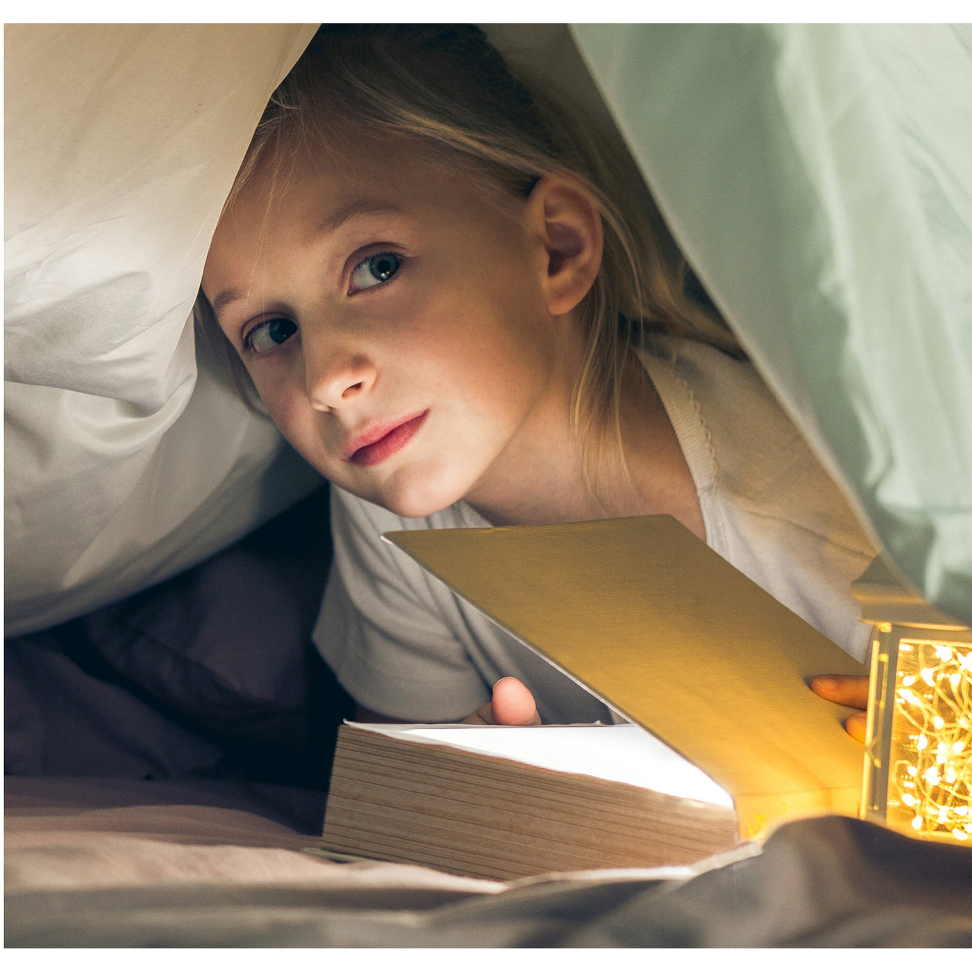 Mädchen liest Harry Potter unter der Decke